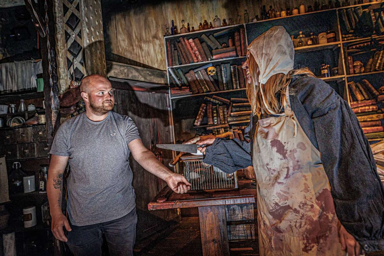 Foto aus dem Hamburg Dungeon, eine Frau in blutigen Klamotten hält ein Messer in Richtung eines  Besuchers