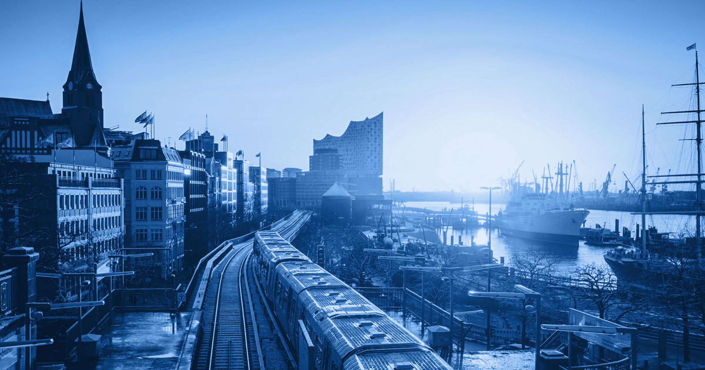 Ein Bild vom Hamburger Hafen mit Blick auf Michel und Elbphilharmonie