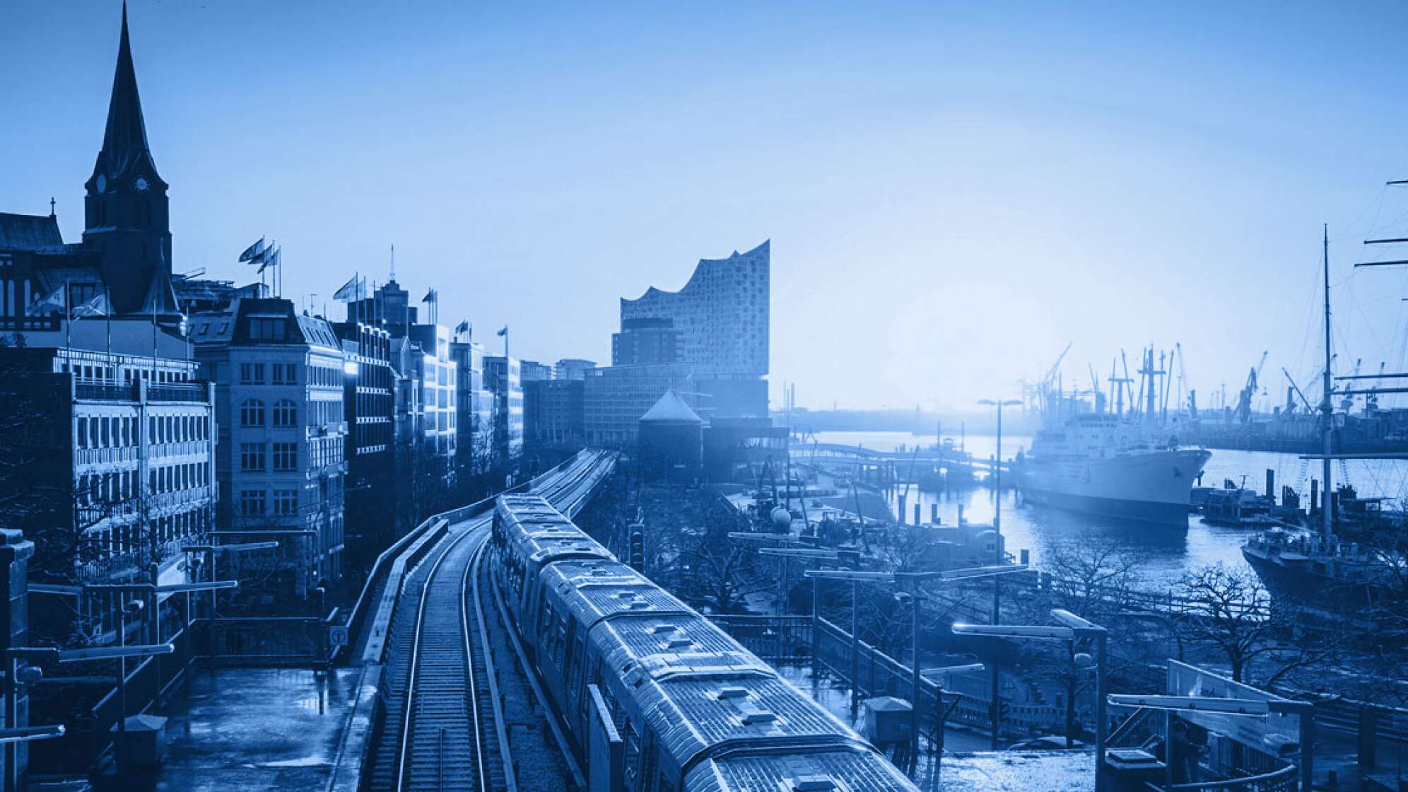 Ein Bild vom Hamburger Hafen mit Blick auf Michel und Elbphilharmonie