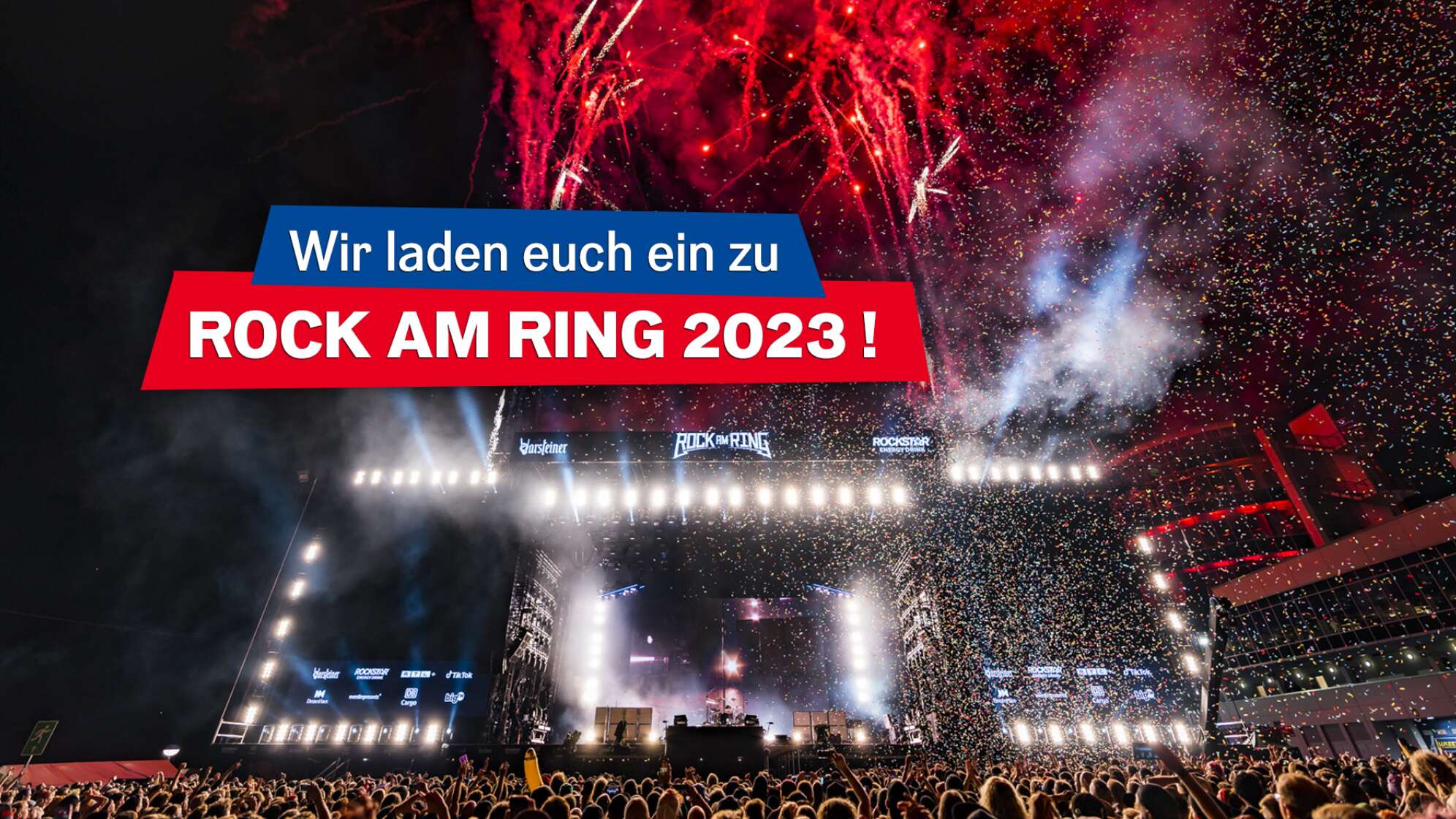 Ein Foto von Rock am Ring 2022 mit Blick auf die Bühne - helle Scheinwerfer und Feuerwerk am Himmel; Darauf der Text "Wir laden euch ein zu Rock am Ring 2023"!