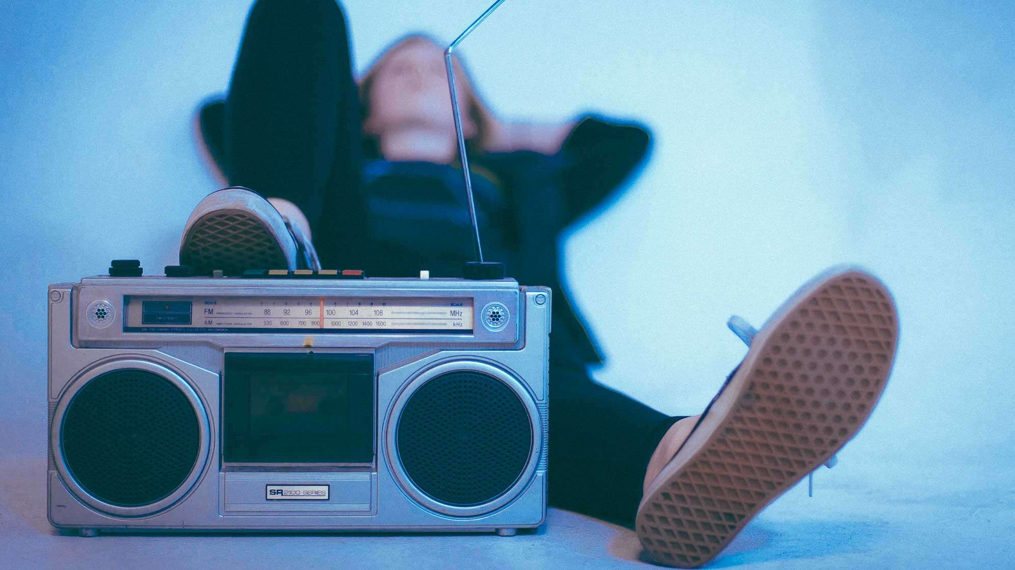 Eine junge Person entspannt, während sie Radio hört.