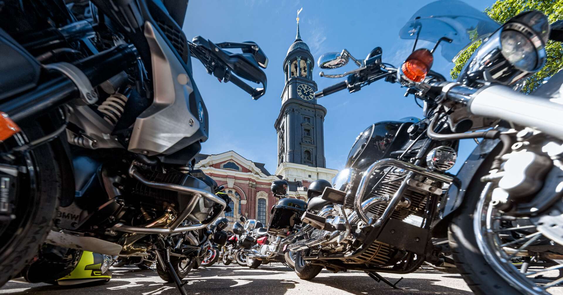 Ein Bild des MOGO Hamburg mit parkenden Motorrädern vor dem Kirchturm St. Michaelis