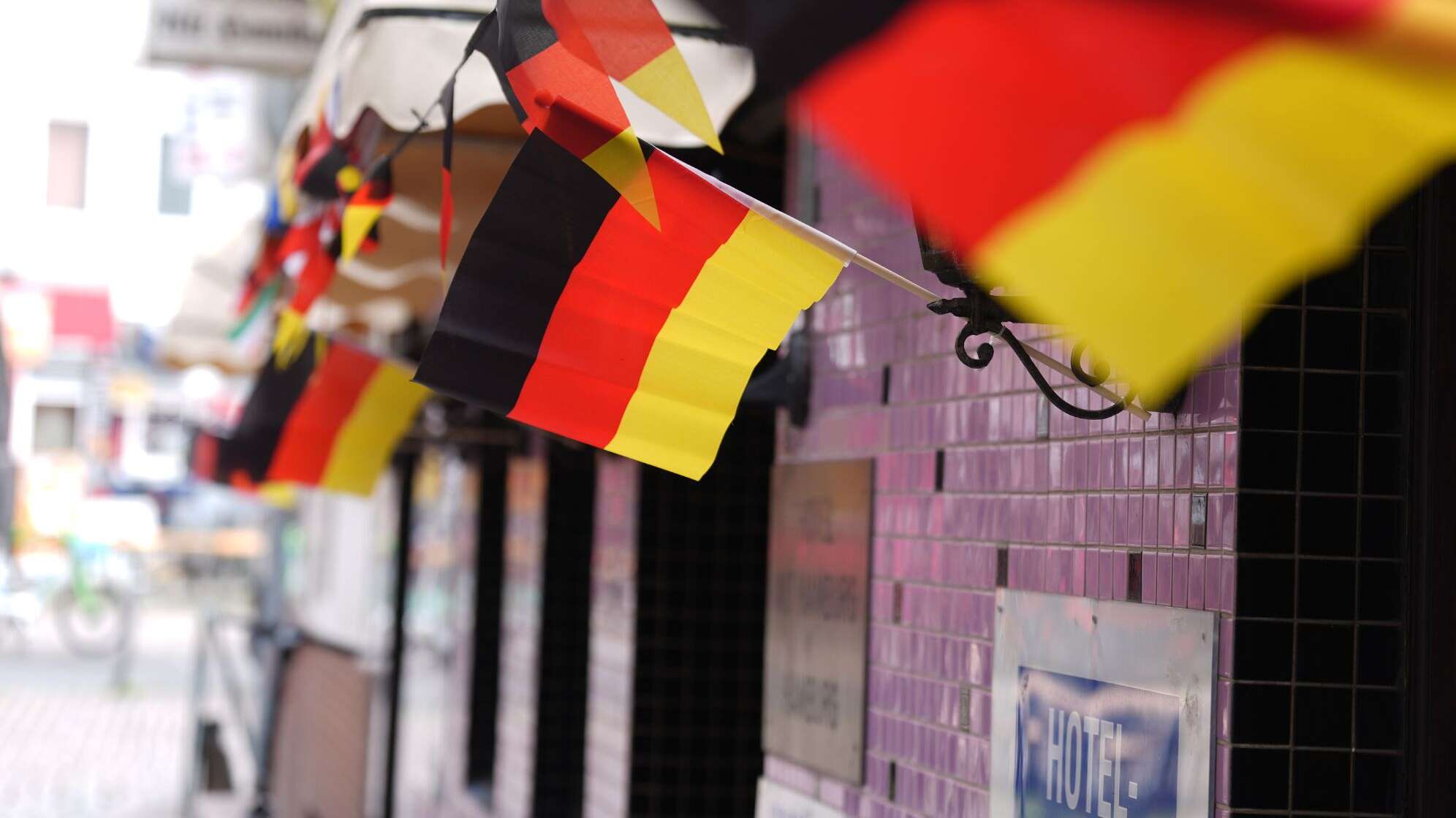 09.06.2026, Hamburg: Deutschland-Fähnchen wehen im Wind vor einer Kneipe und einem Hotel am Hans-Albers-Platz im Stadtteil St. Pauli. Die Fußball-Weltmeisterschaft findet vom 11. Juni bis 19. Juli 2026 in Kanada, Mexiko und den USA statt.