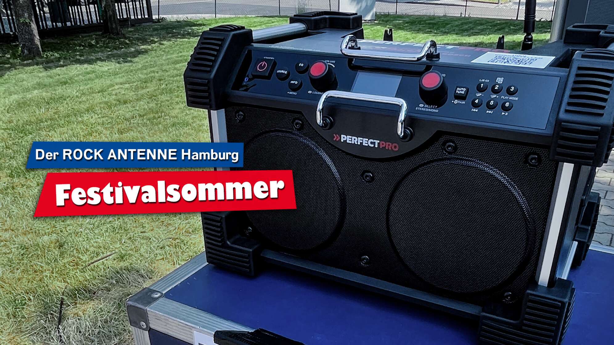 Ein DAB+ Baustellenradio des Modells "RockHart 18V" von PerfectPro auf einem Tisch im Freien, Aufschrift: "Der ROCK ANTENNE Hamburg Festivalsommer"