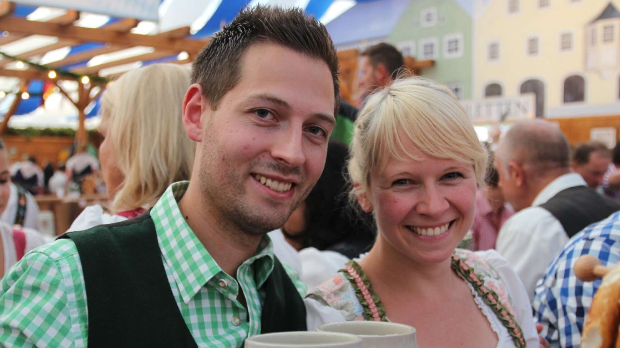 Ein Mann und eine Frau stoßen auf dem Hamburger Oktoberfest mit zwei Maß an