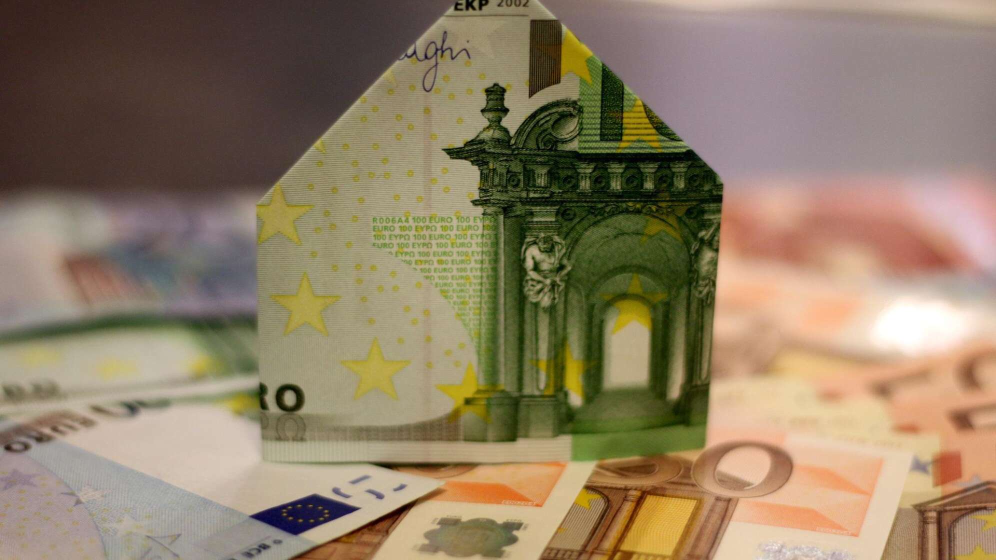 Bild eines zu einem Haus gefalteten 100 Euro Geldscheins