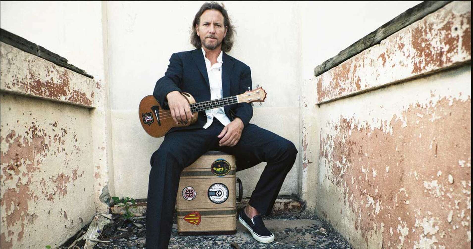 Eddie Vedder mit Gitarre auf Koffer sitzend