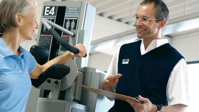 Ein Mann berät eine ältere Frau beim Training