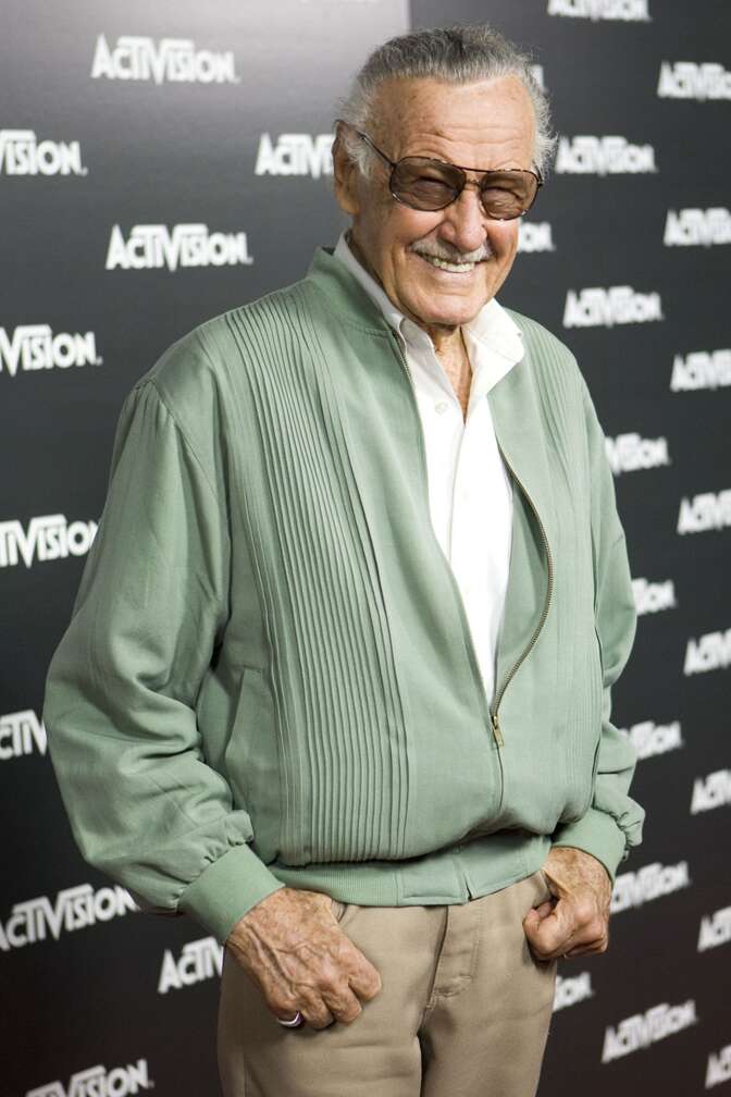 Stan Lee auf dem roten Teppich mit grünen Outfit lächelnd in die Kamera
