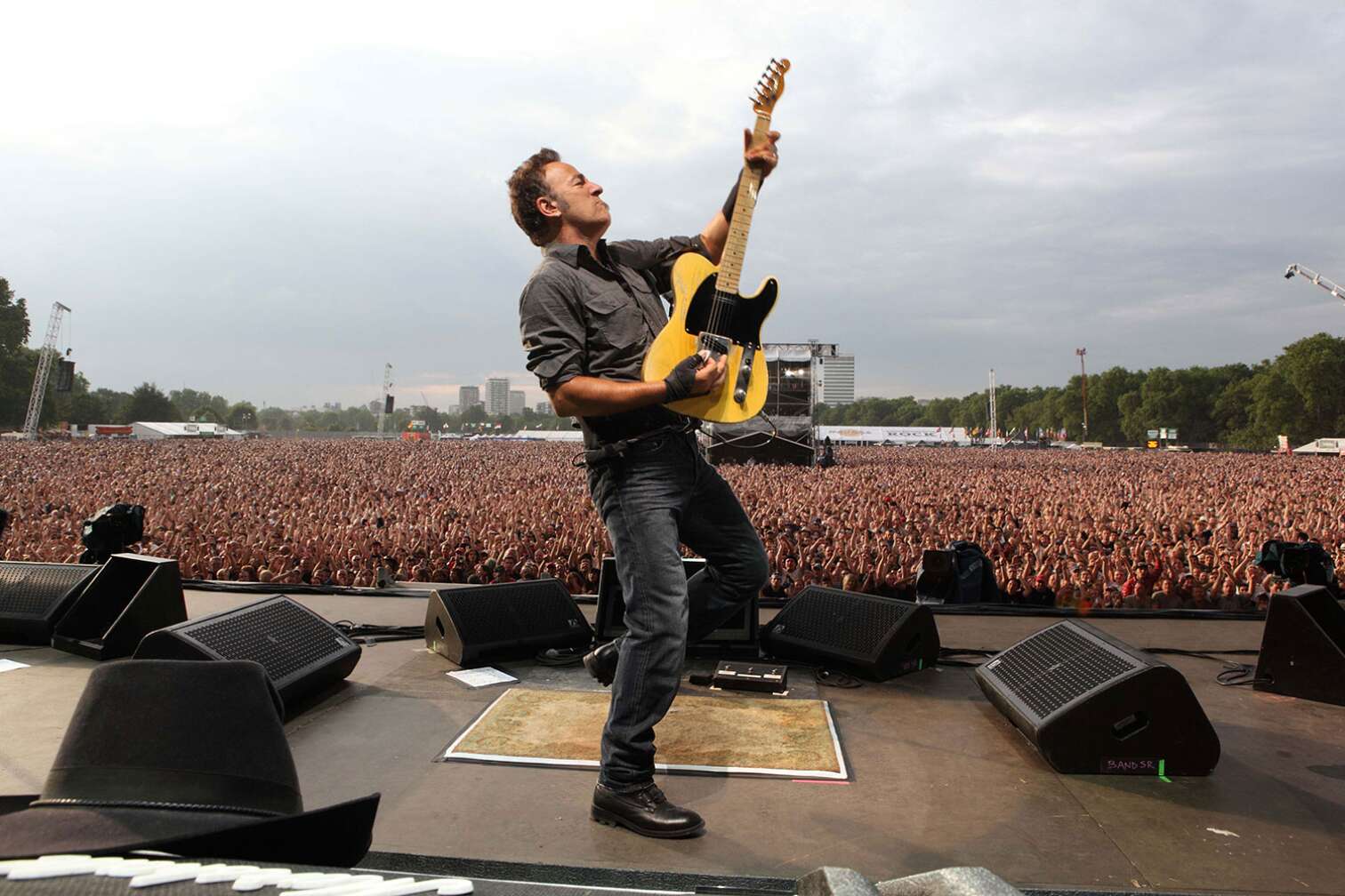 Bruce Springsteen mit E-Gitarre vor jubelnder Menge auf Open-Air-Konzert
