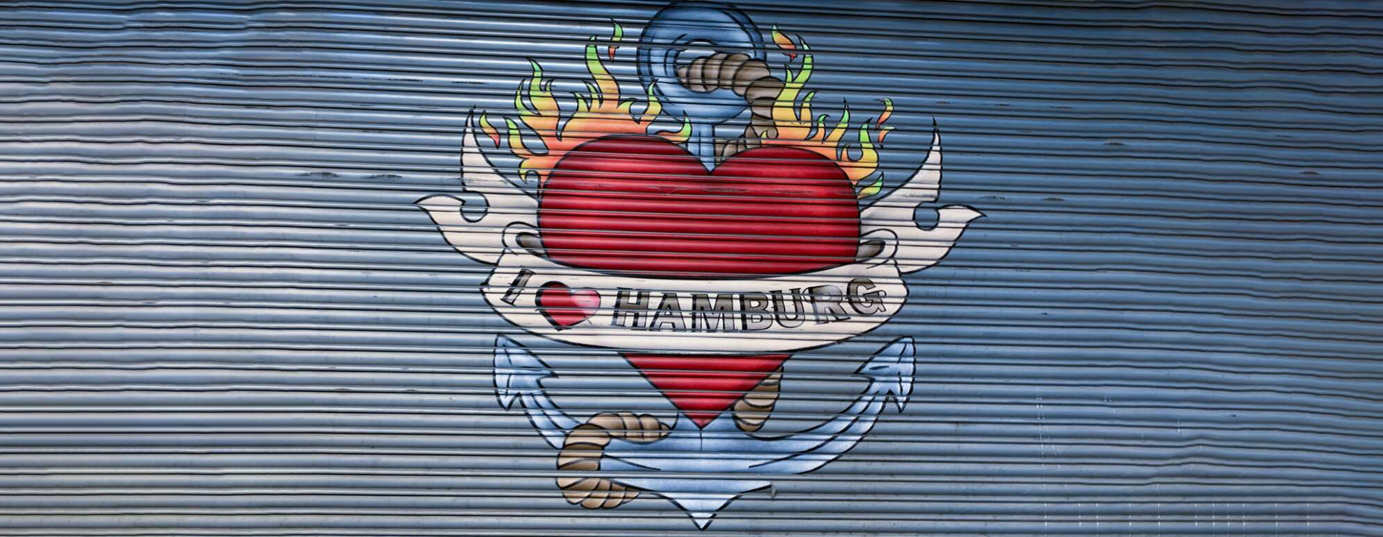 Bild von einem Graffiti auf einem Garagentor im Tattoo-Style: Ein Herz mit Flammen und Anker dahinter, mit Text I love Hamburg