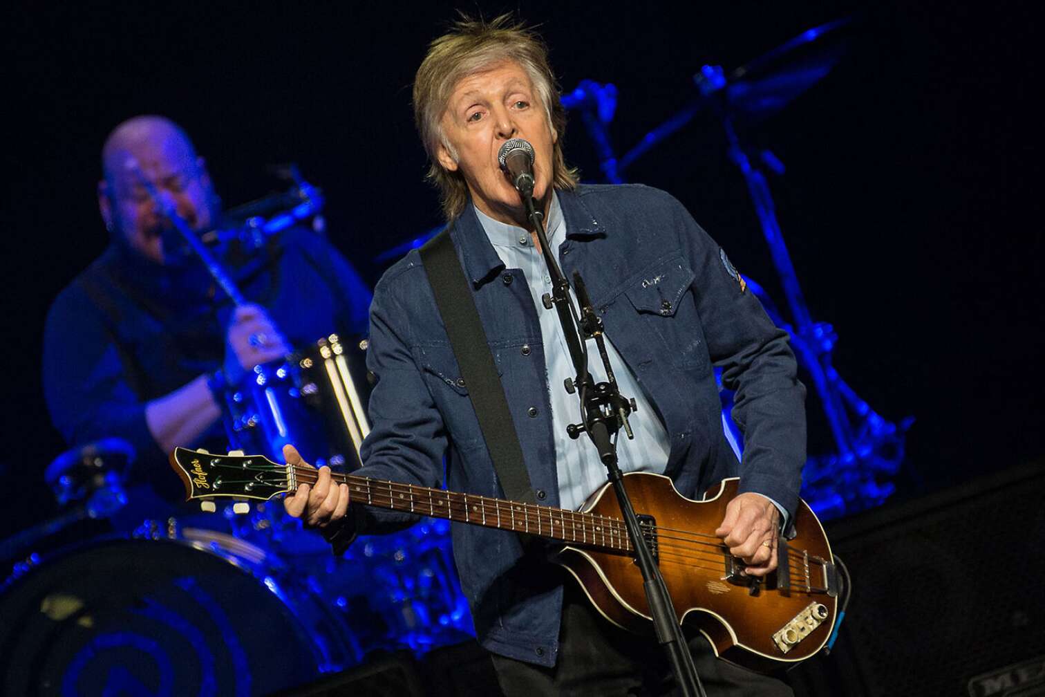 Paul Mccartney mit Gitarre auf der Bühne am singen